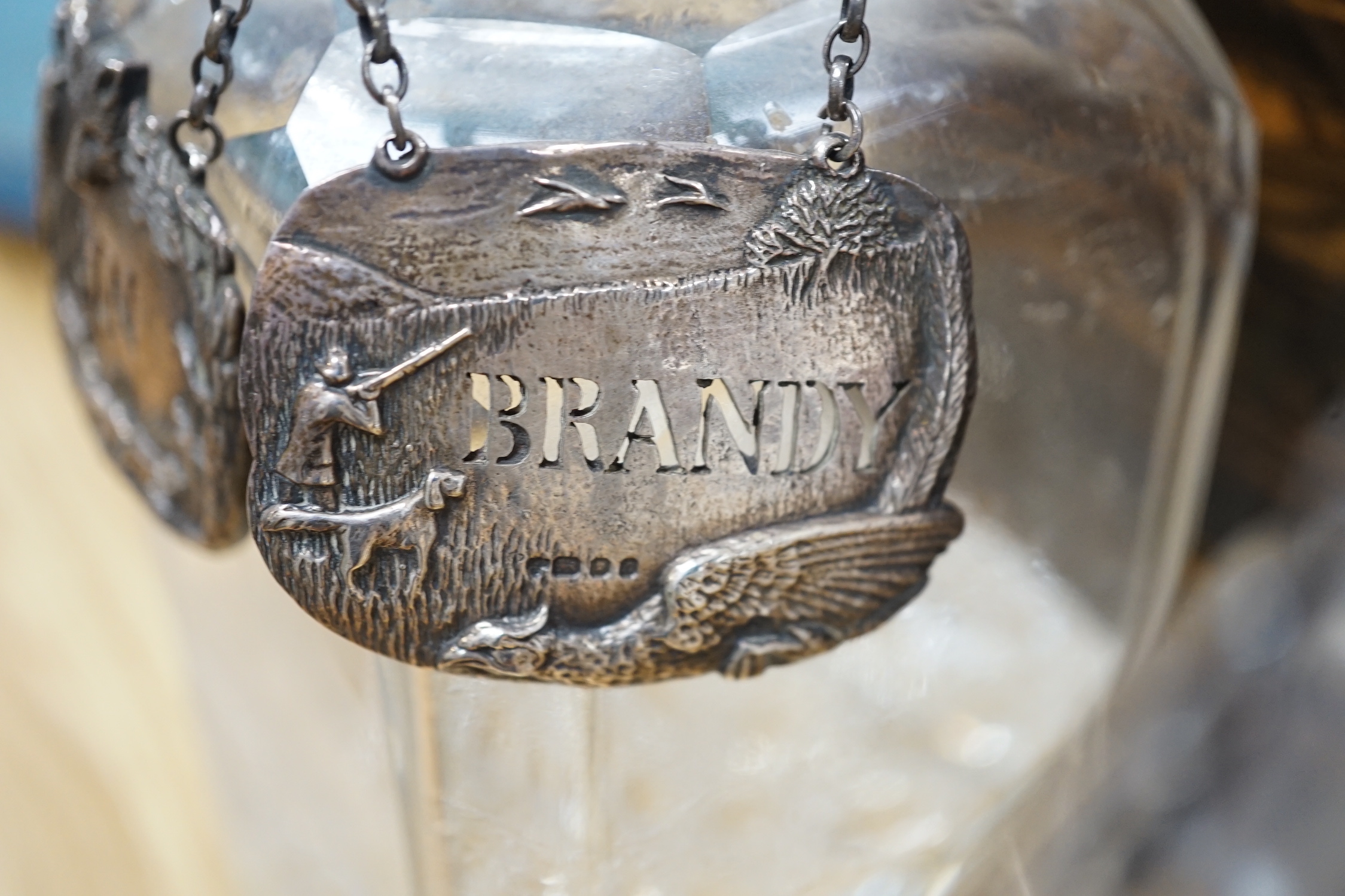 A Victorian coromandel four bottle decanter box with Bramah lock, three silver ‘hunting’ spirit labels and another enamelled, height of box 30cm